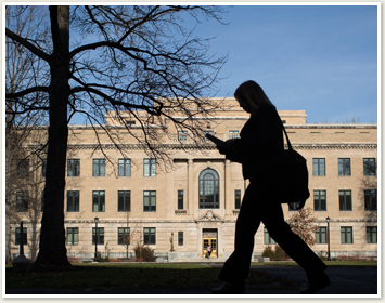 Student in silhouette walking across Ag Quad 